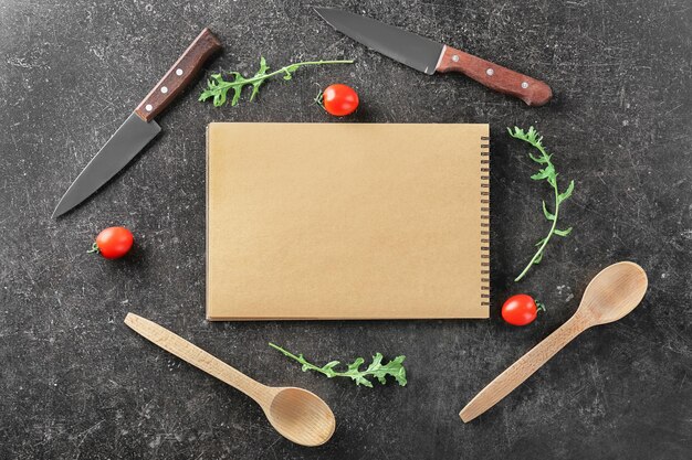 Notebook und Küchenutensilien auf grauem Hintergrund Kochmeisterkurse