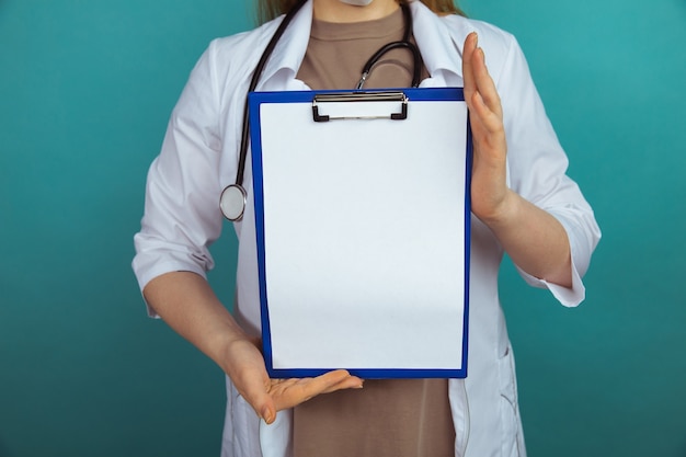 Noticias médicas. Mujer sosteniendo la tableta en el gabinete azul.