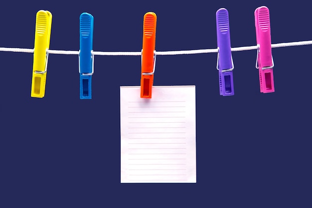Foto notizblock aus papier zur erinnerung an farbige wäscheklammern