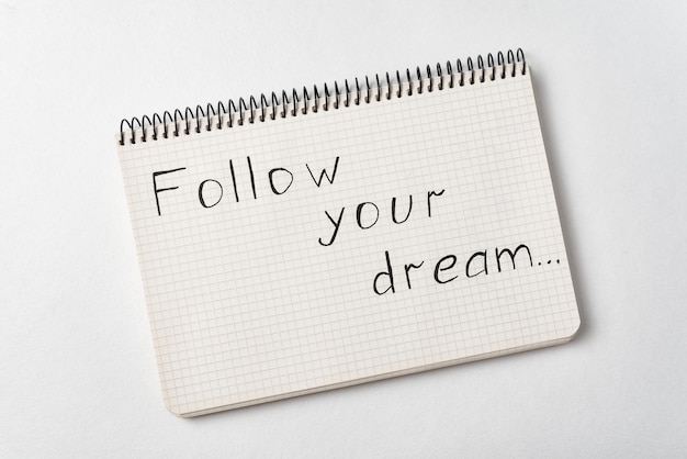 Notizblock mit den Worten Folgen Sie Ihrem Traum auf weißem Hintergrund Handschriftlich