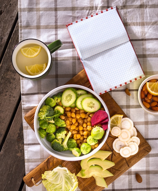 Notizblock mit leeren Seiten und Platte der Draufsicht des gesunden ausgewogenen vegetarischen Essens. Diätessen