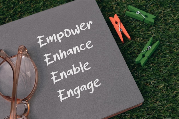 Notizbuch geschrieben mit EMPOWER ENHANCE ENABLE und ENGAGE