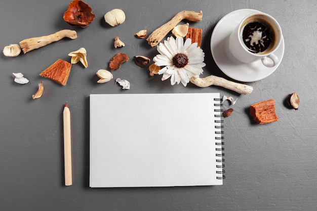 Notizbuch mit Stift, Kaffee und Blume auf Tabelle