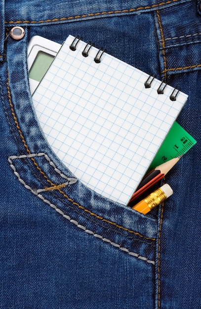 Notizbuch und Bleistift auf Jeanspaket