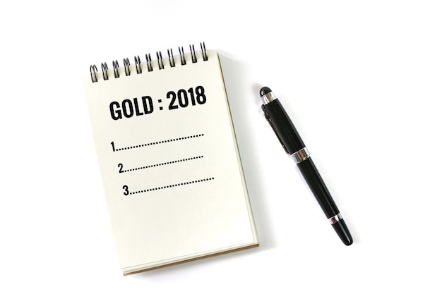 Notizbuch und Stift im Gold 2018 Konzept lokalisiert auf weißem Hintergrund