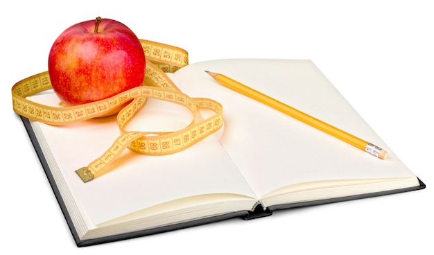 Notizbuch und Stift mit Apfel und Maßband zum Schreiben von Diätnotizen - isoliertes Bild