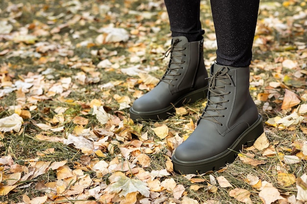 Nova coleção de sapatos femininos de primavera. Pernas femininas esbeltas close-up em botas de couro genuíno.