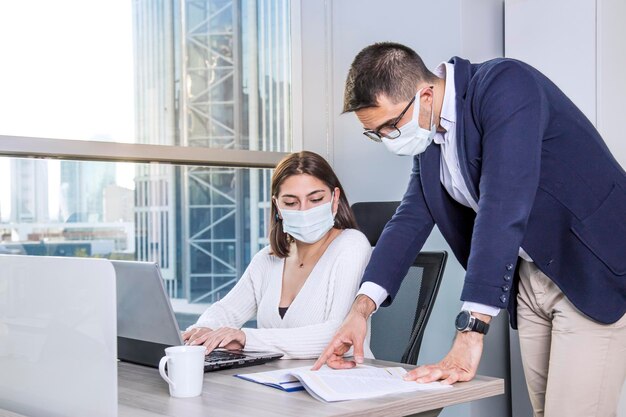 Nova visão de cena de trabalho de conceito normal de um escritório moderno, homens e mulheres, funcionários estão usando máscara