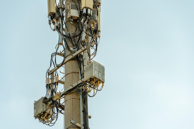 Novas antenas GSM em uma torre alta contra um céu azul para transmitir um sinal de 5g são perigosas para a saúde Poluição por radiação do meio ambiente através de torres de celular A ameaça de extinção