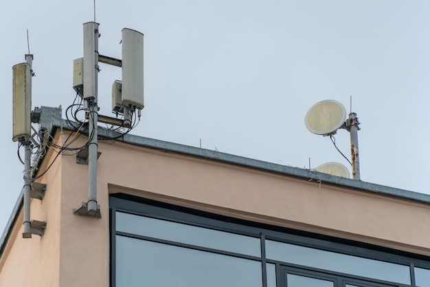 Novas antenas GSM no telhado de um prédio para transmitir um sinal de 5g são perigosas para a saúde Radiação poluição do meio ambiente através de torres de celular A ameaça de extinção da população