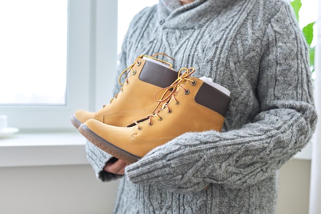 Foto novas botas de outono de inverno de couro marrom à prova d'água para mulheres nas mãos de mulheres