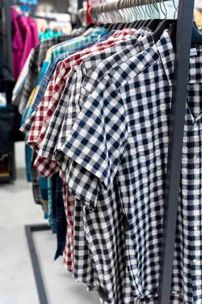 Novas camisas xadrez com mangas curtas em um cabide em uma loja de roupas