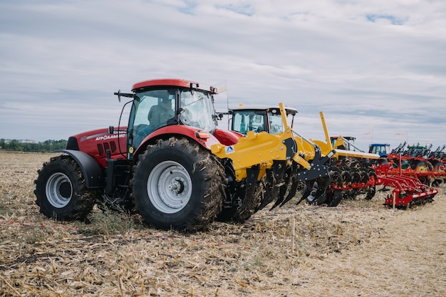 Novas máquinas agrícolas, tratores em movimento no campo de demonstração na agro exhibition