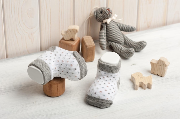 Novas meias de bebê na placa de madeira branca recém-nascido e conceito de bebê