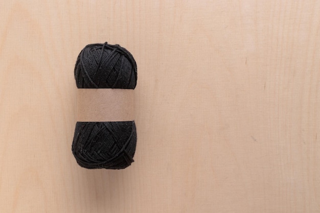 Novelo de fio de algodão para crochê feito à mão em um fundo de madeira de cor clara