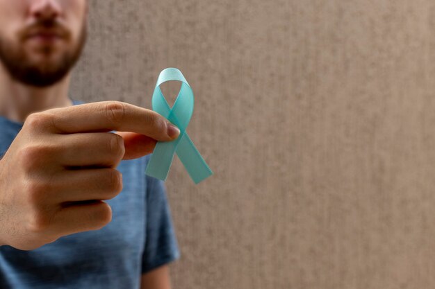 Novembro azul. mês de prevenção do câncer de próstata. homem segurando a fita azul. a saúde dos homens.