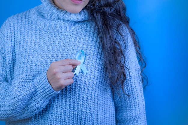Foto novembro mês de conscientização do câncer de próstata mãos de uma mulher segurando uma fita azul