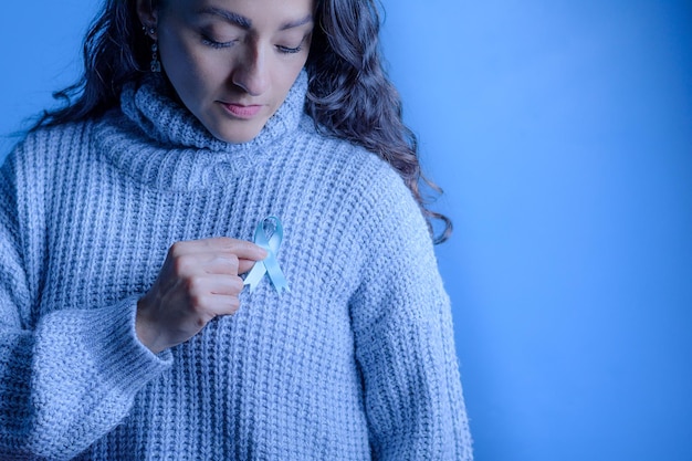 Novembro Mês de Conscientização do Câncer de Próstata Mãos de uma mulher segurando uma fita azul