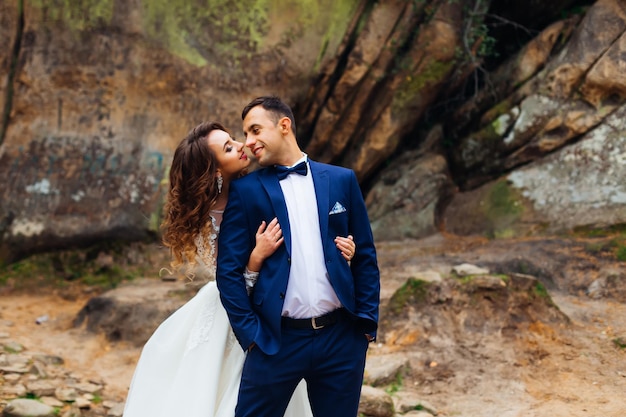 La novia abraza al novio por la parte de atrás y se miran