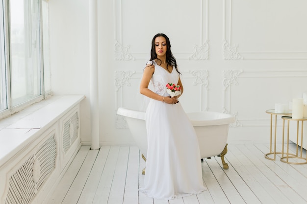 Novia afroamericana en vestido por la mañana preparándose para la boda en una habitación de hotel