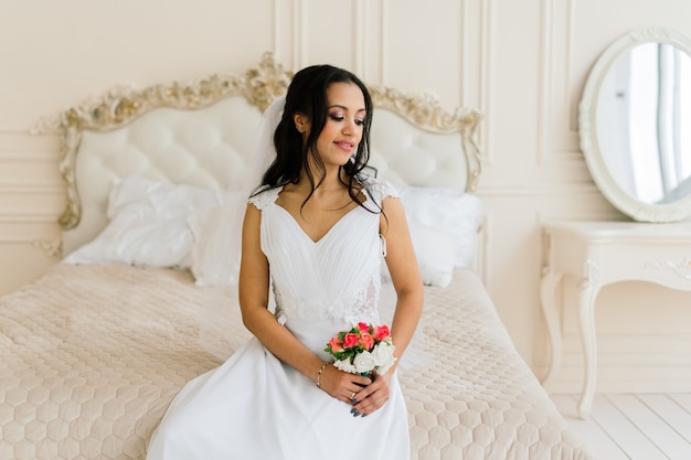 Novia afroamericana en vestido por la mañana preparándose para la boda en una habitación de hotel