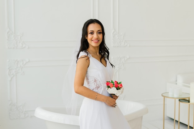 Novia afroamericana en vestido por la mañana preparándose para la boda en una habitación de hotel