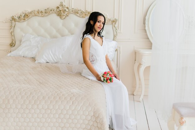 Novia afroamericana en vestido por la mañana preparándose para la boda en una habitación de hotel