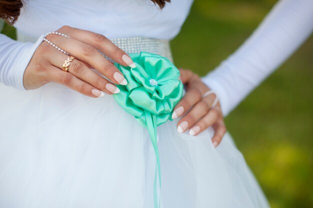 La novia ajusta la flor en su vestido