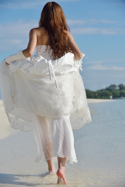 novia asiática con un velo en la playa en el cielo y el mar azul. luna de miel en la isla fantástica en verano