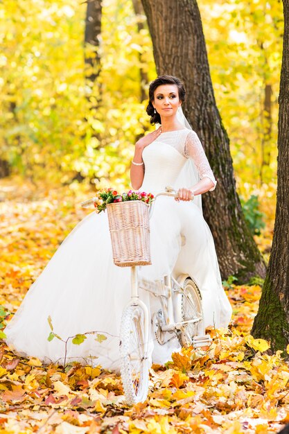 Novia en bicicleta en otoño naturaleza