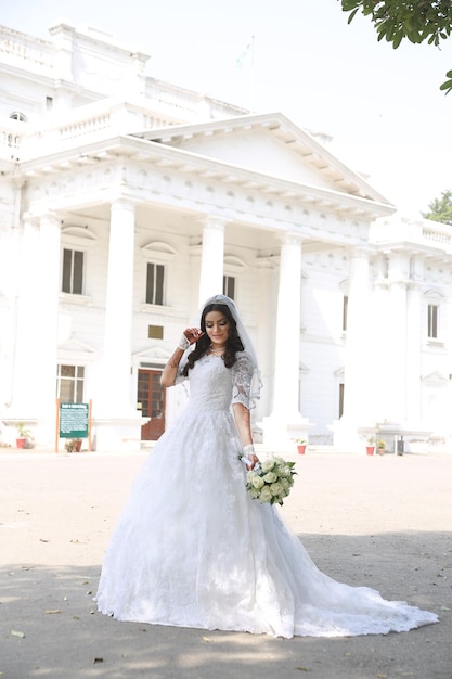 novia de boda y ramo de novia en mano y maquillaje de novia paquistaní