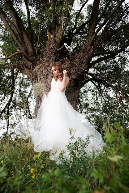 Novia bonita joven en vestido de novia blanco