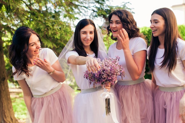 La novia bromea con sus damas de honor y muestra su anillo de bodas