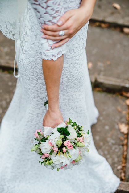 Novia camina con ramo de boda en sus manos