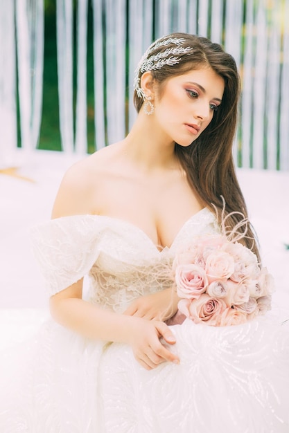 Novia cerca del arco de boda con flores.