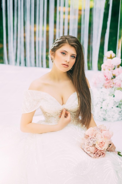 Novia cerca del arco de boda con flores.