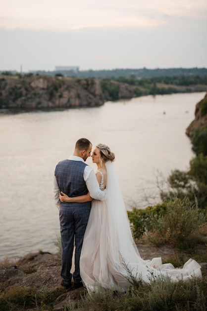 Novia chica rubia y novio cerca del río