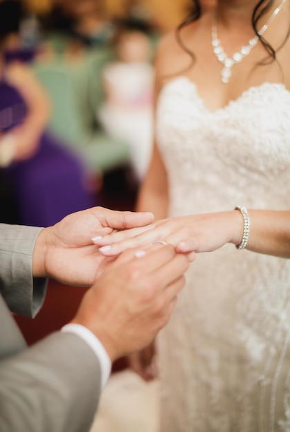 Una novia coloca un anillo de bodas en su dedo.