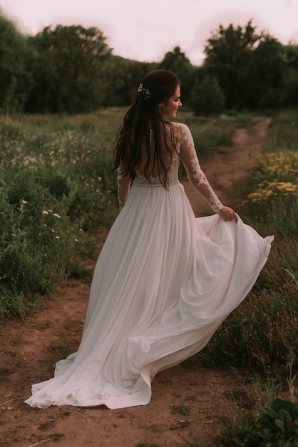 Novia corriendo por el parque con vestido