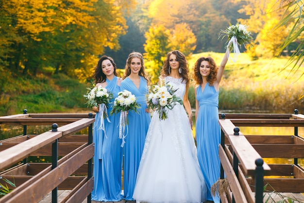 Novia con damas de honor en el parque el día de la boda.