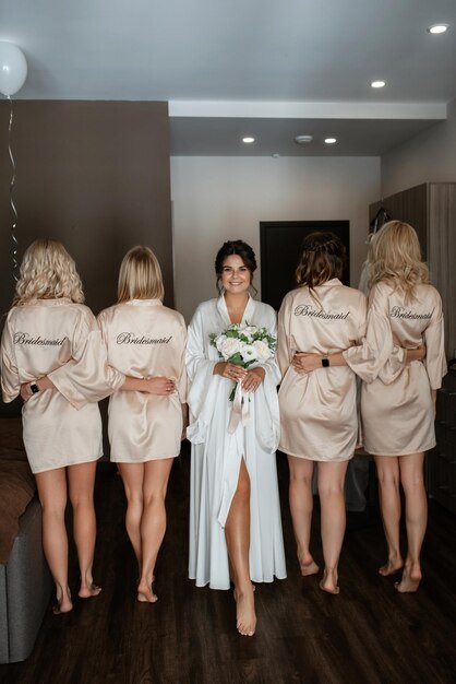 la novia con las damas de honor en vestidos ligeros antes de la boda