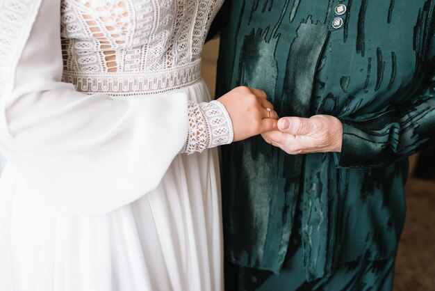 Foto novia en el día de la boda de la mano de su madre