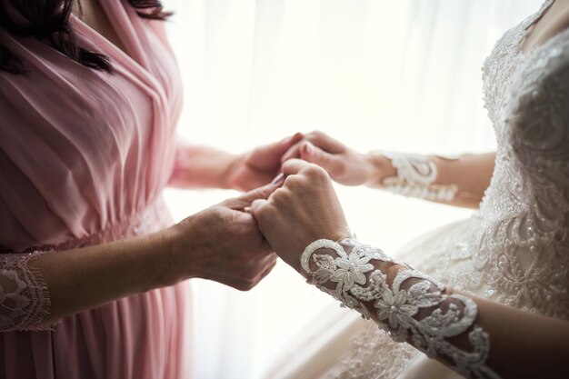 Novia el día de la boda sosteniendo las manos de su madre Concepto de relación entre madres e hijas