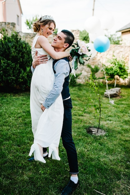 Novia elegante sonrisa feliz, el novio sostiene en las manos y bailando.