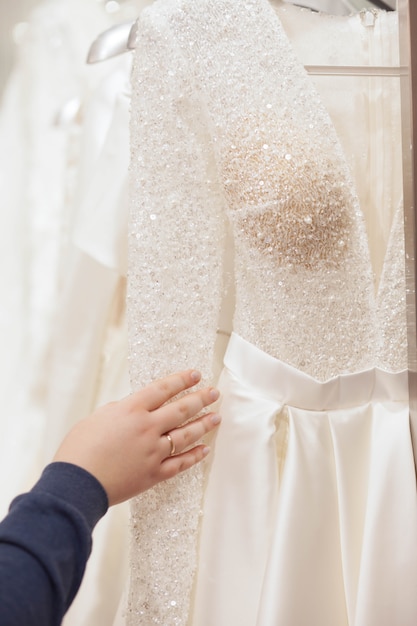 Foto la novia elige un vestido de novia en el salón de lujo.