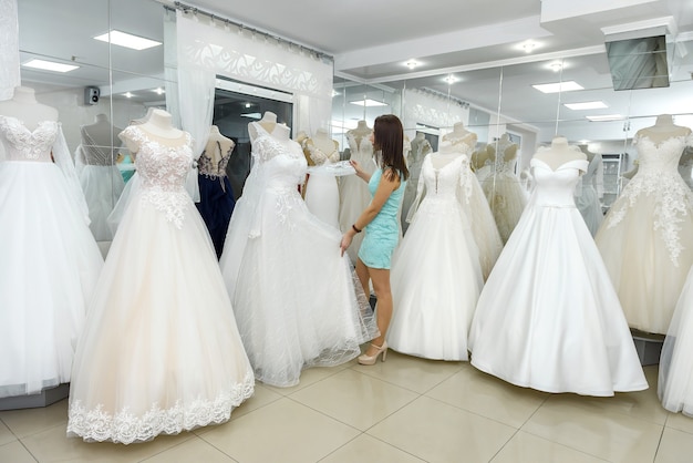 Novia eligiendo increíble vestido de novia en un maniquí