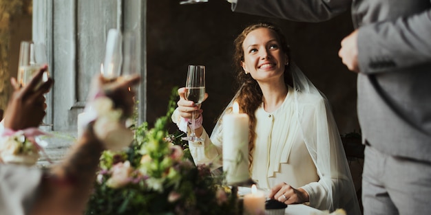 Novia escuchando un discurso en la mesa de recepción de boda