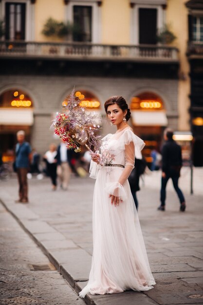 La novia está con un hermoso patrón de flores como una máscara en Florencia, una novia elegante con un vestido de novia