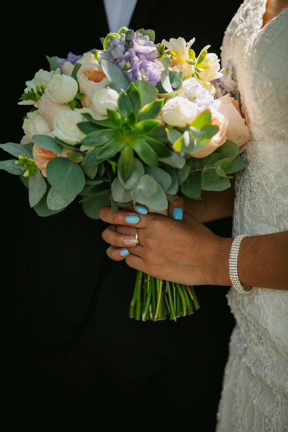 la novia está sosteniendo un ramo de novia, en un paseo. La novia con un vestido blanco con un hermoso ramo.