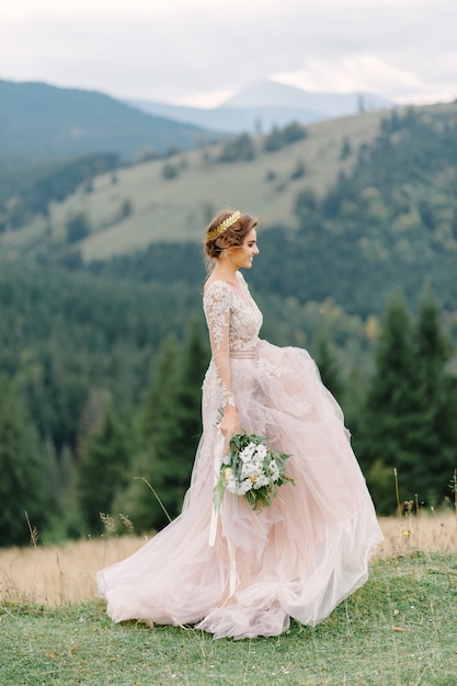 Novia girando con velo falda del vestido de novia en el bosque de pinos